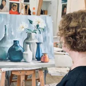 Oil Painting Ala Carte session – participant holding a brush painting still life on canvas in oil painting class