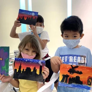 Children exploring different art mediums such as acrylic and watercolour in a holiday immersion class