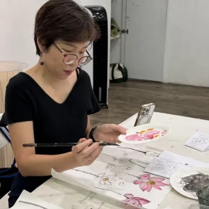 Students learning traditional Chinese ink painting techniques in Singapore