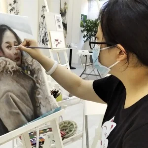 Student painting a landscape in an oil painting trial class at AZ @ Paya Lebar Studio.