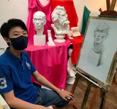 Student with completed observational plaster cast drawing and sketching artwork