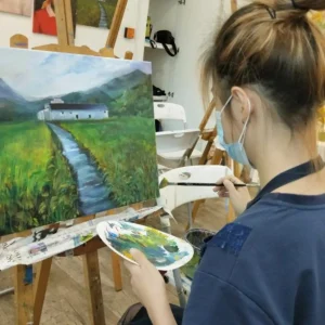 A student applying acrylic paint on canvas in a vibrant trial session at AZ Paya Lebar Studio