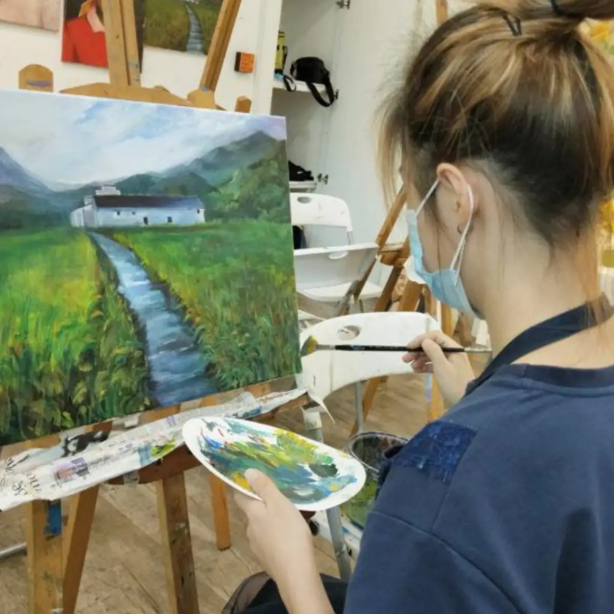 A student applying acrylic paint on canvas in a vibrant trial session at AZ Paya Lebar Studio