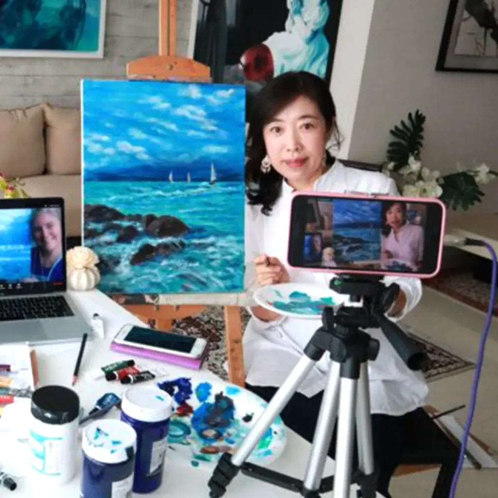 Participant painting vibrant artwork with acrylics during a Zoom live art session