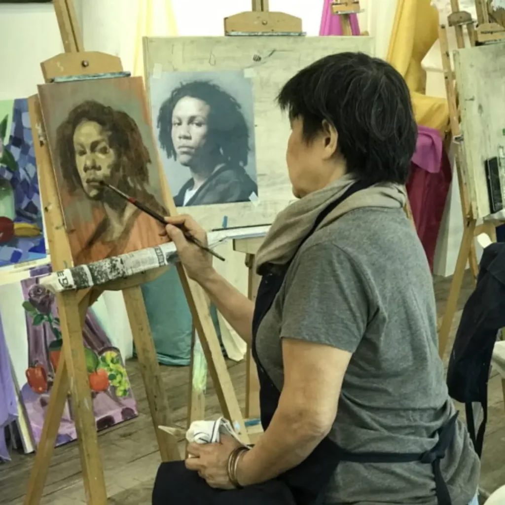 Student working on a portrait using watercolour and pencil in an art class