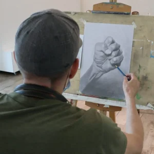 キャンバスに油絵を描く受講生の集中した様子