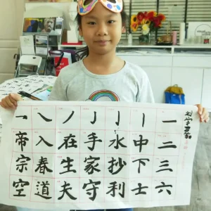 子供たちが伝統的な中国の筆と墨を使って水墨画を学ぶ様子