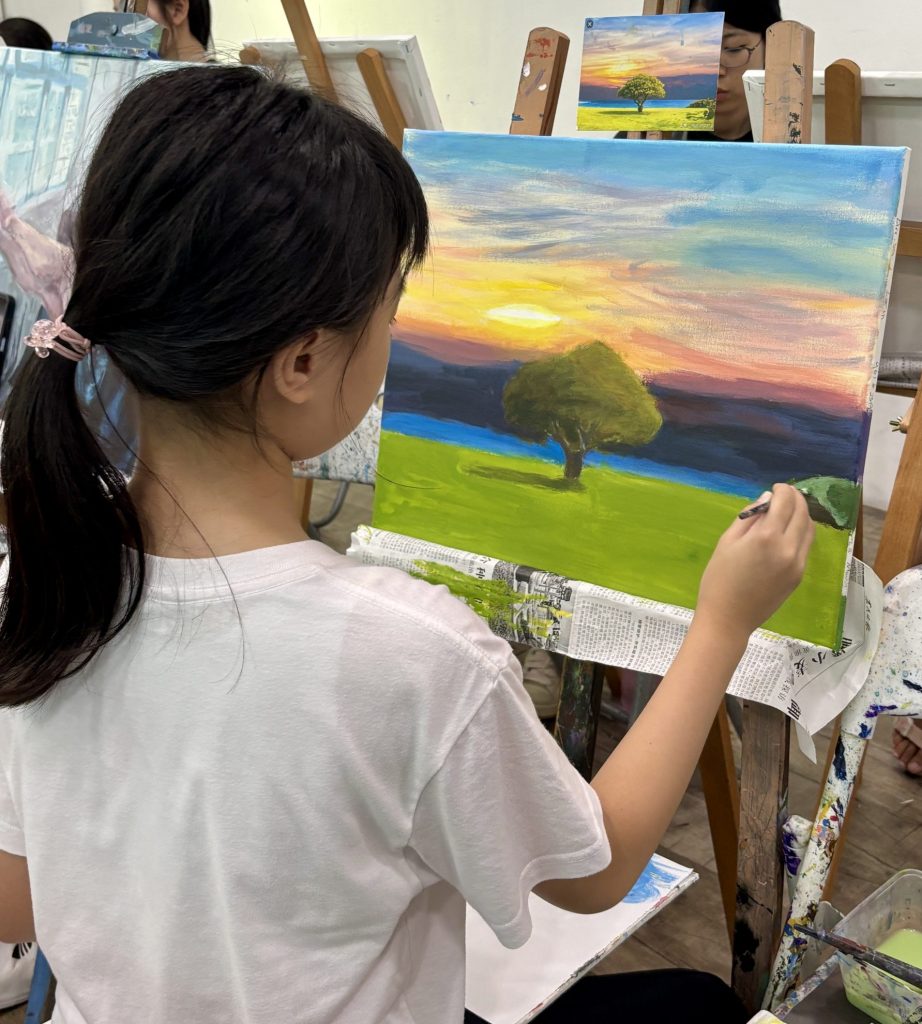 Photo of a girl painting a landscape acrylic painting of a tree
