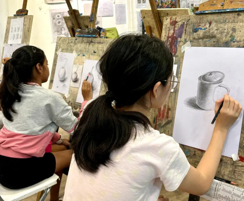 Student is focusing on her still-life sketching